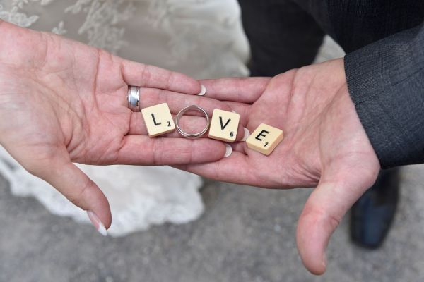 H�nde von Hochzeitspaar mit Love